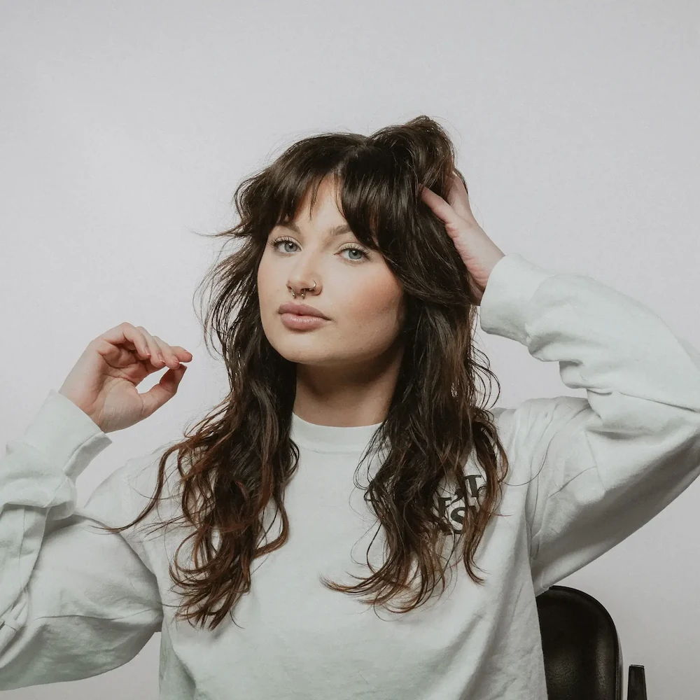 Women’s long textured haircut with curtain bangs styled at Mailroom Barber Co.