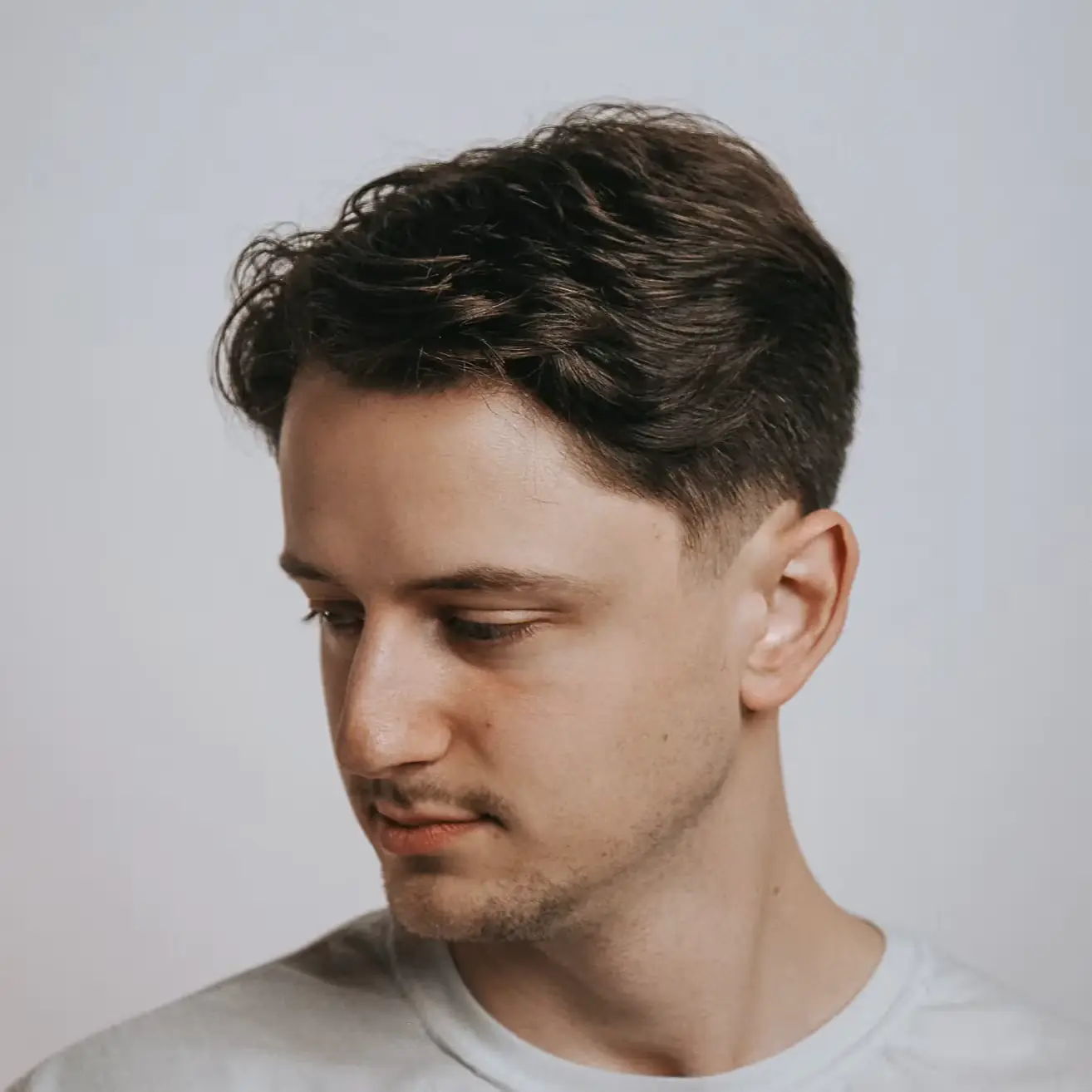 Clean and timeless men’s haircut featuring a medium-length top and taper fade