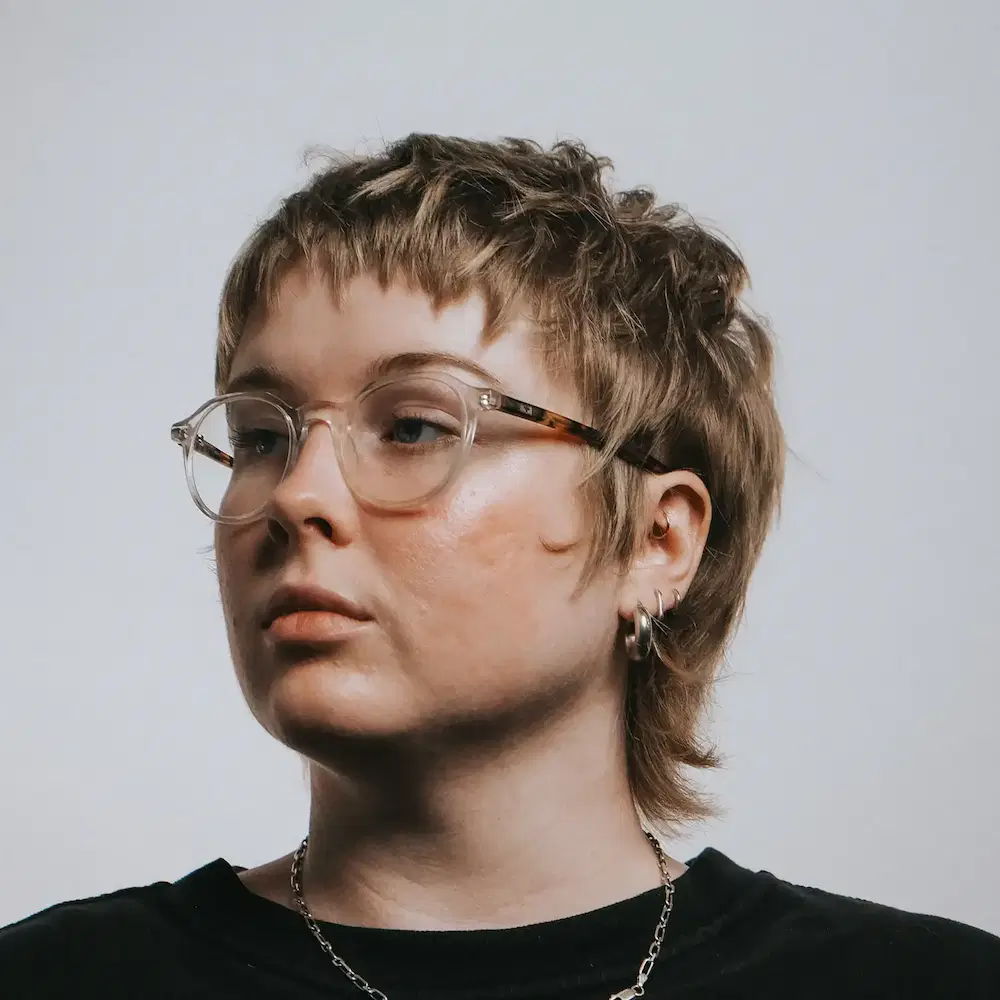 Unisex short hair textured haircut on a woman with glasses