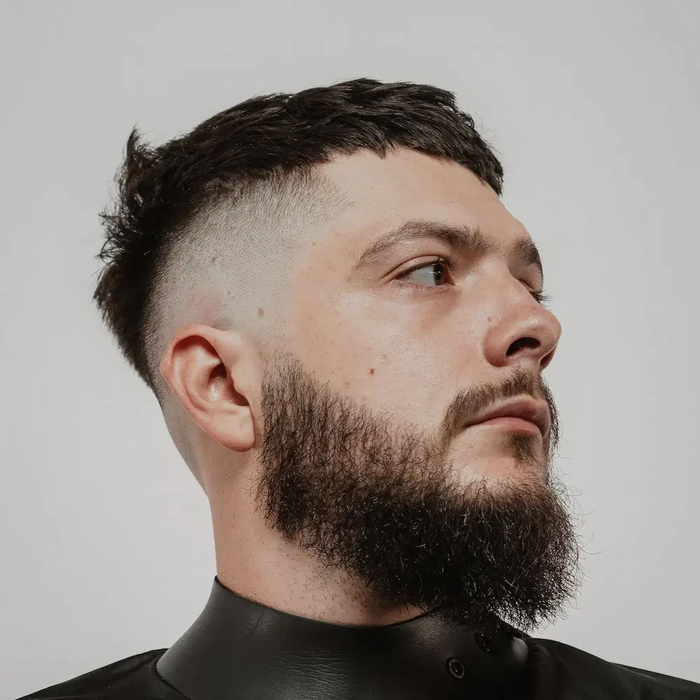 Man with mid length beard and short textured skin fade haircut