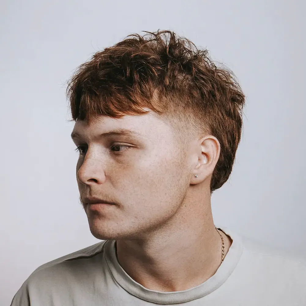 Trendy men's textured fade haircut for red hair at Mailroom Barber Co.